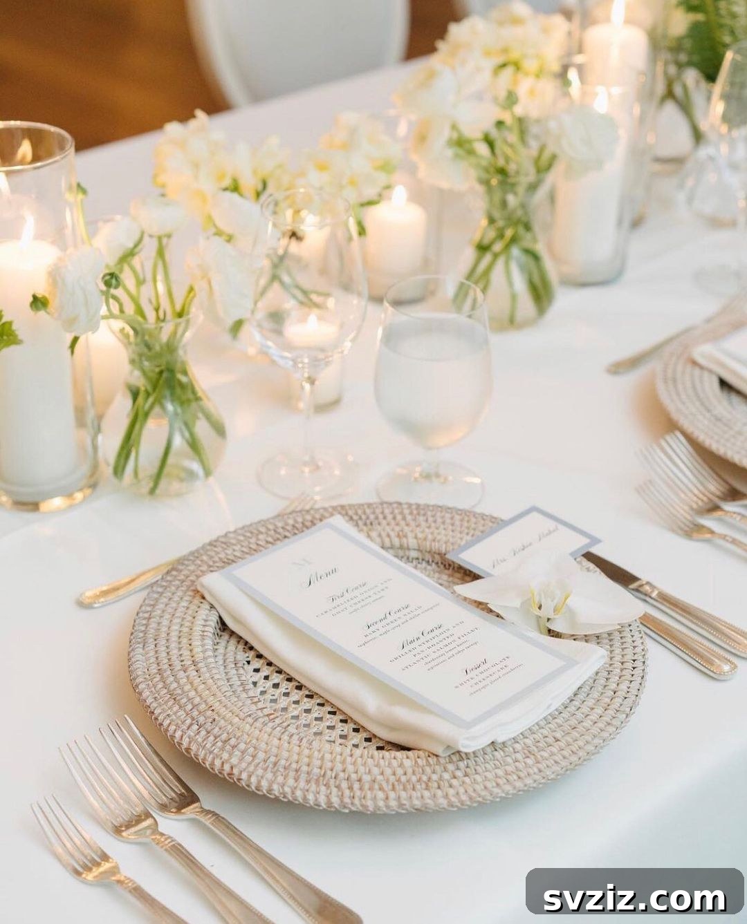 Boho-chic wedding table with white roses, white candles, and rustic wicker plates for decor.