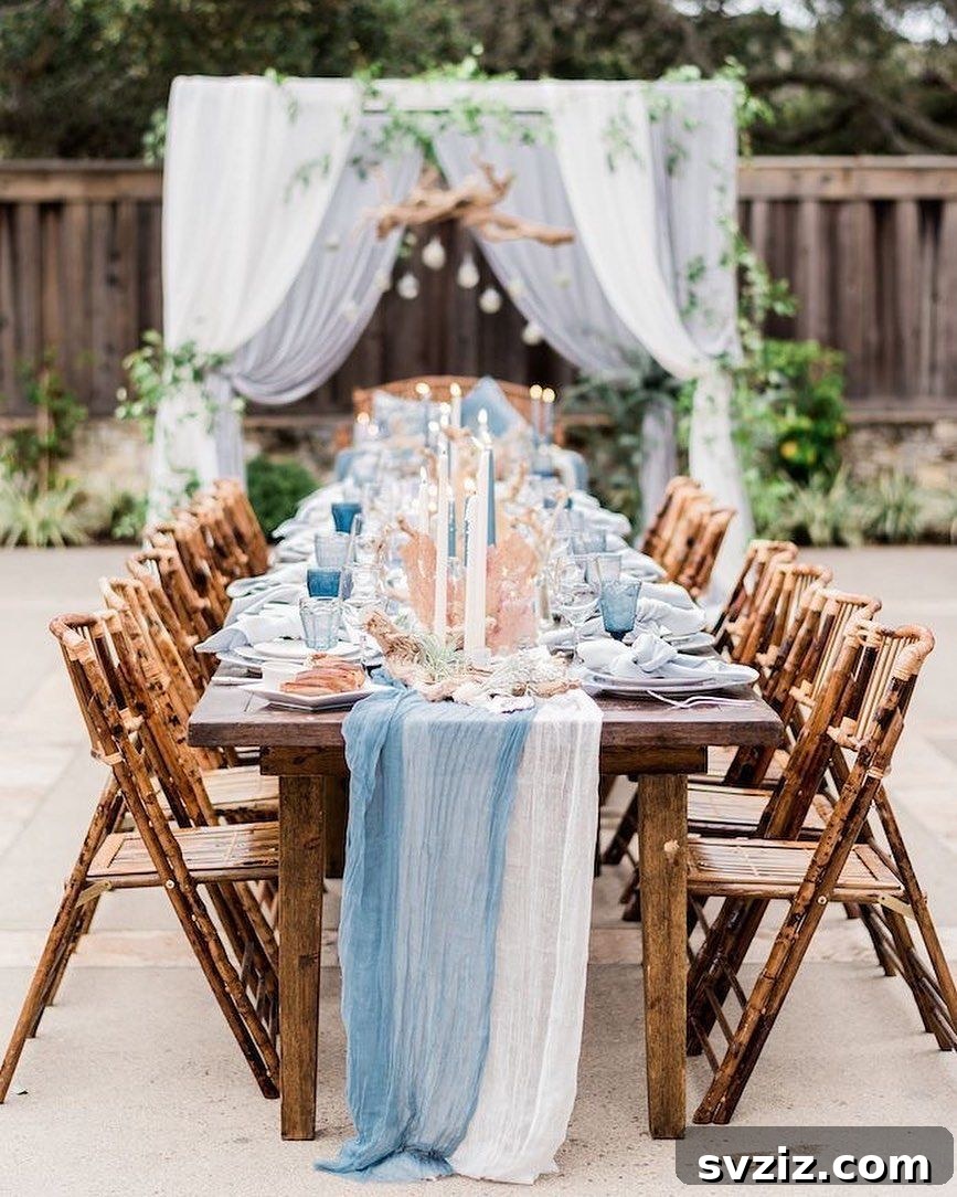 Coastal wedding table with blue and white decor, cheesecloth runners, blue goblets, candles, and decorative seashells.