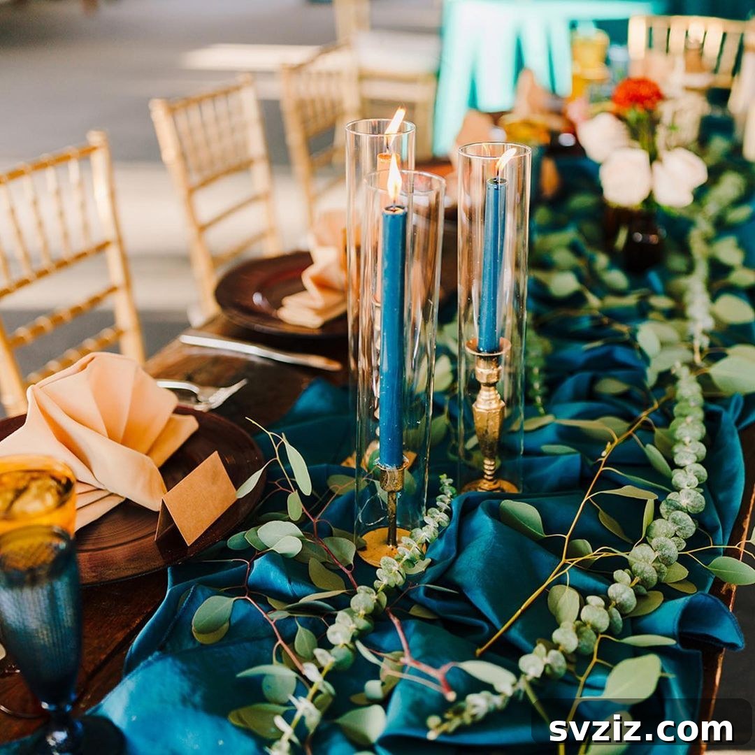 Exotic Mediterranean Wedding Table Decor with peacock green-blue runner, silver leaf eucalyptus, string of pearls succulents, and turquoise vintage glassware.