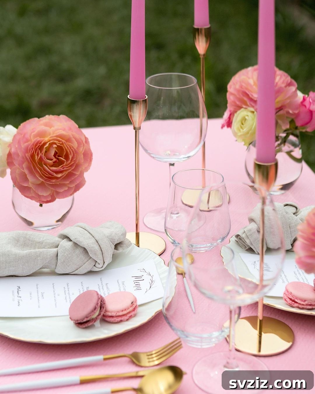 All-pink wedding table decor with garden roses, taper candles, and delightful macarons.